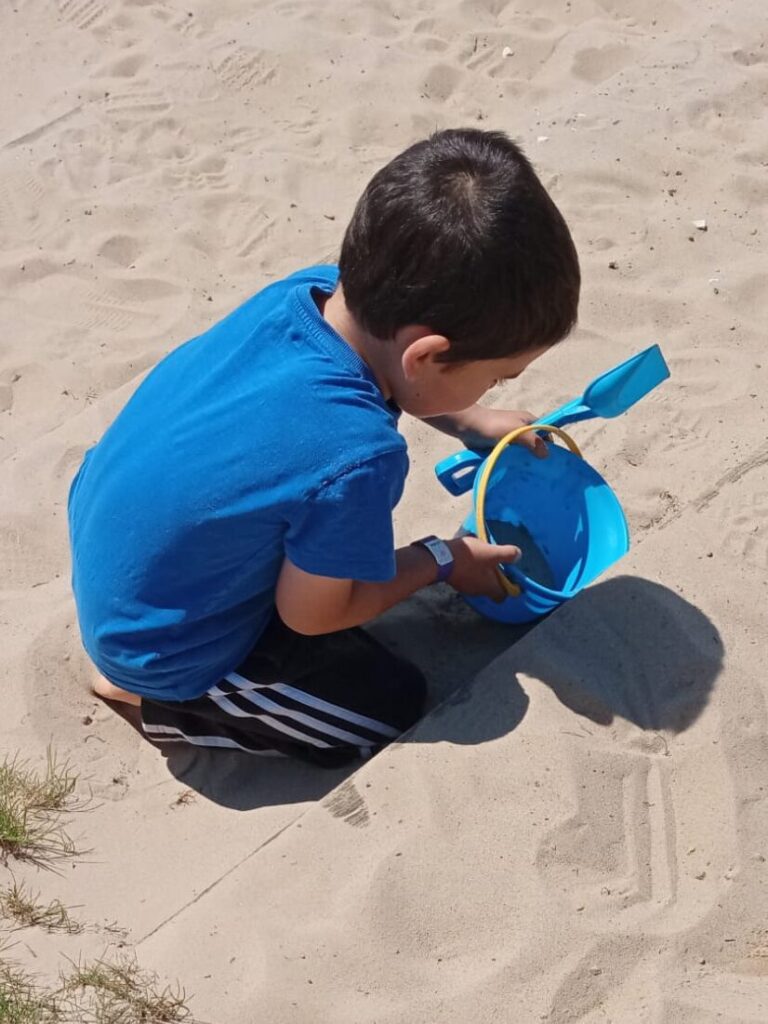 Boy playing in the sand at Williams Den